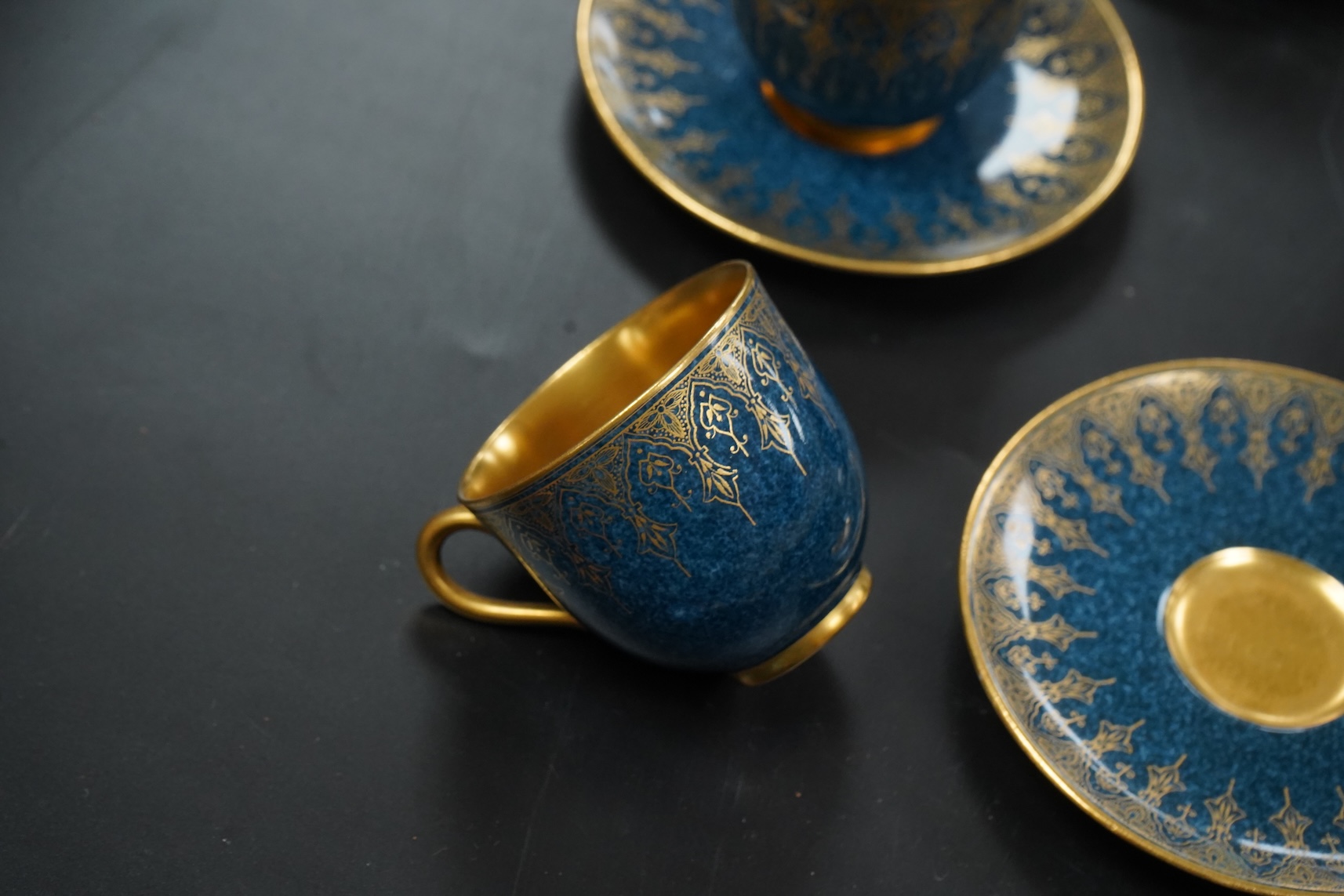 A set of six Royal Worcester cups and saucers, powder blue and gilt decoration, together with a set of six silver and enamel teaspoons